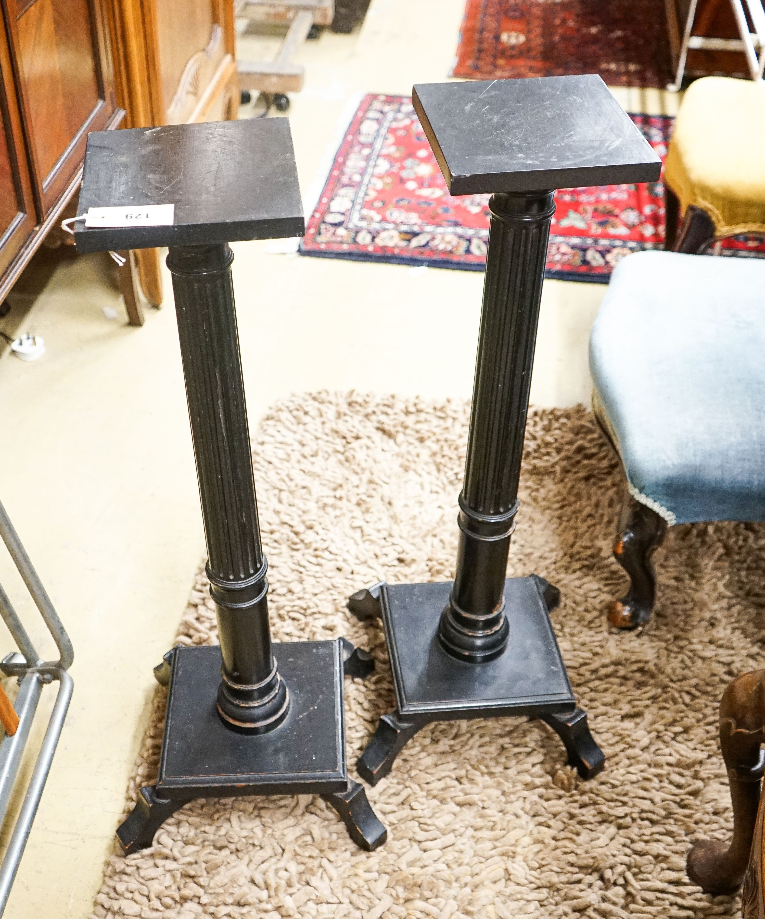 A pair of fluted ebonised plant stands, height 80cm